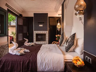 a bedroom with a large bed with two swans on it at Riad Zagouda in Marrakech