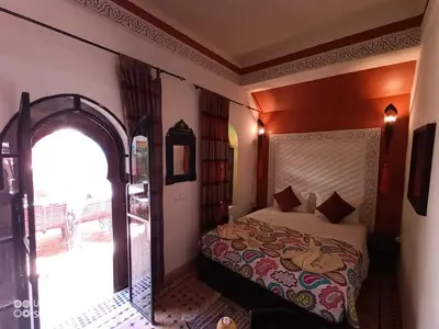 a bedroom with a bed and an arched doorway at Riad Zagouda in Marrakech