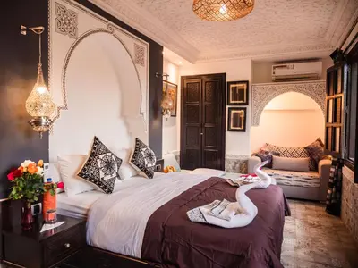 a bedroom with two swans sitting on a bed at Riad Zagouda in Marrakech