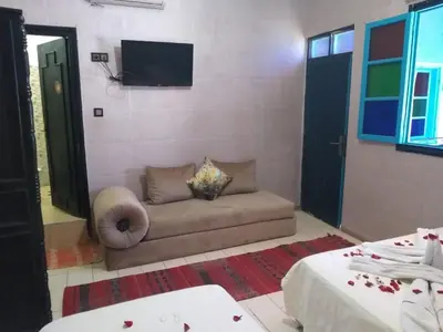 a living room with a couch and a flat screen tv at Hôtel Agnaou in Marrakech