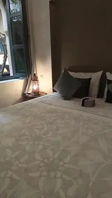 a bedroom with a large white bed with a window at RIAD KERDOUSS in Marrakech