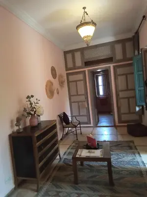 a living room with a coffee table and a chandelier at RIAD KERDOUSS in Marrakech