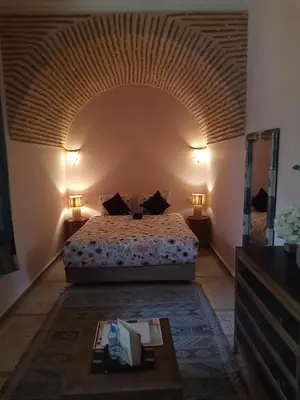 a bedroom with a bed and two lamps and a table at RIAD KERDOUSS in Marrakech