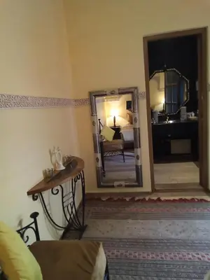 a living room with a mirror and a couch at RIAD KERDOUSS in Marrakech
