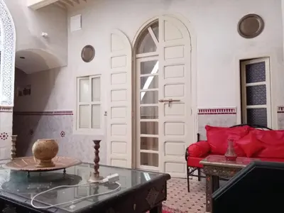 a living room with a red couch and a table at house miss rose in Marrakech
