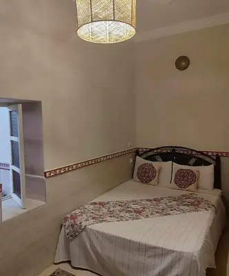 a bedroom with a bed and a chandelier at house miss rose in Marrakech