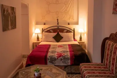 a hotel room with a bed and a chair at house miss rose in Marrakech