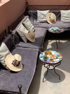 two beds with hats on top of them and a table at RIAD LE PATIO ROMANTIQUE in Marrakech