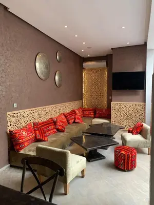 a living room with a couch with red pillows at RIAD LE PATIO ROMANTIQUE in Marrakech