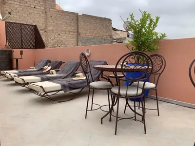 a patio with a table and chairs and a bed at RIAD LE PATIO ROMANTIQUE in Marrakech
