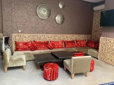 a living room with a couch and a table and chairs at RIAD LE PATIO ROMANTIQUE in Marrakech