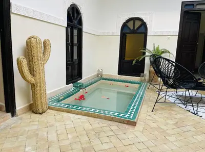 a swimming pool in a house with a cactus at Riad Dialna in Marrakech