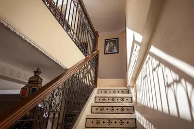 a staircase in a home with sunlight streaming through the windows at Riad Salman in Marrakech