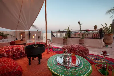 a living room with a table and chairs and a piano at Riad Salman in Marrakech