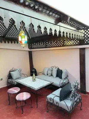 a living room with a couch and a table and chairs at Riads Dar ZAO - logements entiers in Marrakech