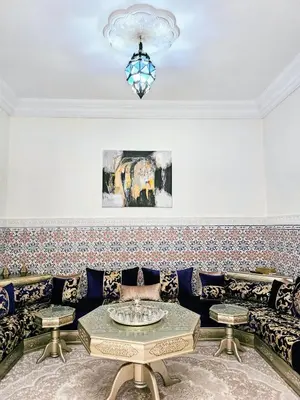 a living room with a couch and a chandelier at Riads Dar ZAO - logements entiers in Marrakech