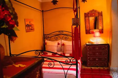 a bedroom with a bed and a dresser with a mirror at Riad zen&zin in Marrakech