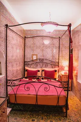 a bedroom with a large bed with red pillows at Riad zen&zin in Marrakech