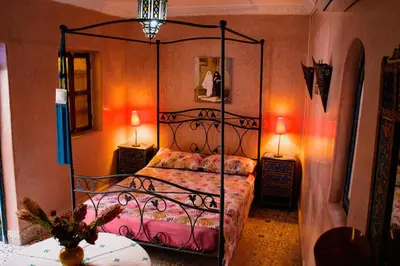 a bedroom with a metal bed with two tables and two lamps at Riad zen&zin in Marrakech