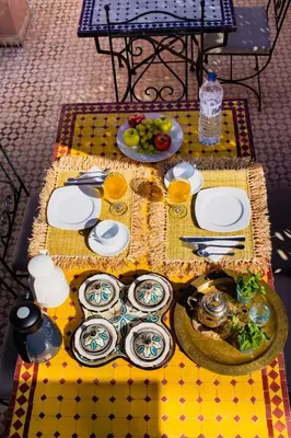 a table with plates of food on a yellow table cloth at Riad zen&zin in Marrakech