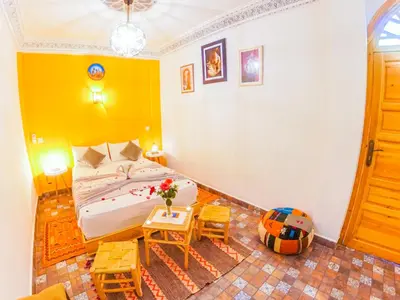 a bedroom with a bed and a table and chairs at Riad Dar Yassine in Marrakech