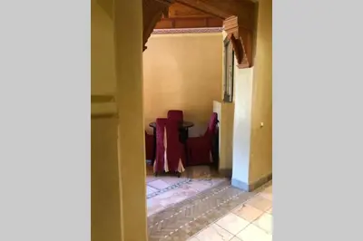 a dining room with red chairs and a table at Bel appartement au Rez-de-jardin dans la palmeraie in Marrakech