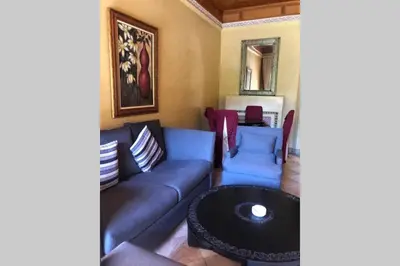 a living room with a couch and a table at Bel appartement au Rez-de-jardin dans la palmeraie in Marrakech