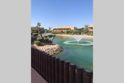 a view of a pond with a fountain at Bel appartement au Rez-de-jardin dans la palmeraie in Marrakech