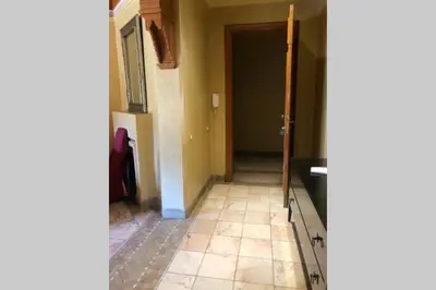 a hallway with a door and a tile floor at Bel appartement au Rez-de-jardin dans la palmeraie in Marrakech