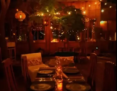 a dining table in a restaurant at night at Jnan Lotf Marrakech - Le Jardin de la Bienveillance in Marrakech
