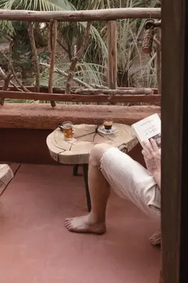 a person sitting at a table with two cups of coffee at Jnan Lotf Marrakech - Le Jardin de la Bienveillance in Marrakech