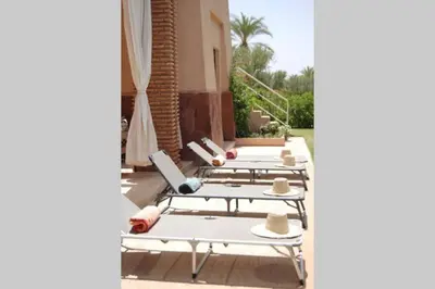 a row of tables with hats on them on a patio at Villa Selma avec piscine chauffée in Marrakech