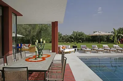 a patio with a table and chairs and a pool at Villa LOULA in Marrakech