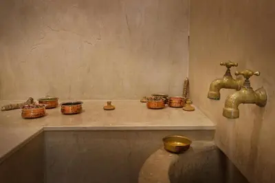 a bathroom with a sink and two faucets and a toilet at Villa LOULA in Marrakech