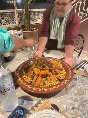 a person sitting at a table with a plate of food at 
