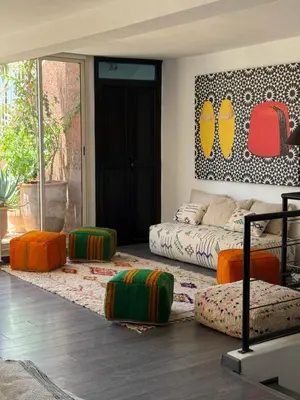a living room with a bed and ottomans at 