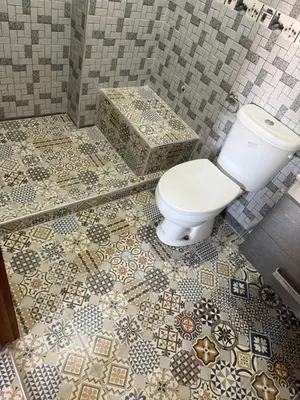 a bathroom with a toilet and a tiled floor at Julie's Private Apartment in Marrakech