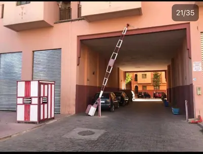 a ladder leaning against a building with a car garage at Julie's Private Apartment in Marrakech