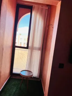 a small table in front of a window with a table at Julie's Private Apartment in Marrakech