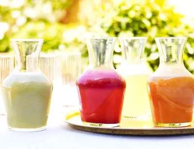three vases of different colored liquids on a plate at Riad L'Hôtel Marrakech in Marrakech