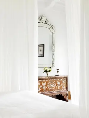 a bedroom with a bed and a mirror at Riad L'Hôtel Marrakech in Marrakech