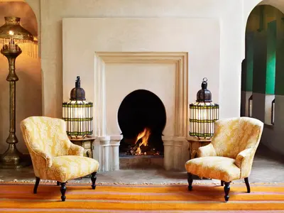 a living room with two chairs and a fireplace at Riad L'Hôtel Marrakech in Marrakech