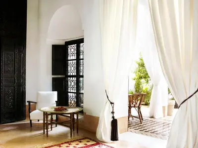 a room with white curtains and a table and chairs at Riad L'Hôtel Marrakech in Marrakech