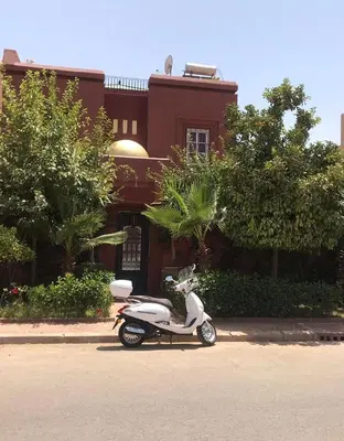 a white scooter parked in front of a building at Riad Al Jawhar in Marrakech