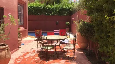 a patio with a table and chairs in a courtyard at Riad Al Jawhar in Marrakech