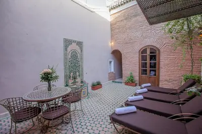 a patio with a table and chairs and a tableasteryasteryasteryasteryasteryastery at Riad KHOL Bohémia in Marrakech
