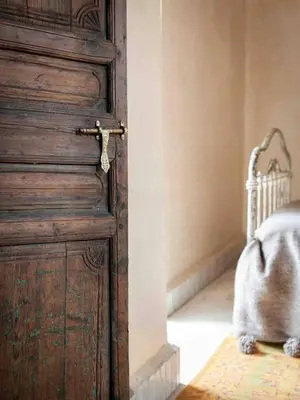 a wooden door in a room with a bed at Riad KHOL Bohémia in Marrakech