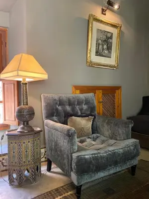 a living room with a chair and a lamp at Riad KHOL Bohémia in Marrakech