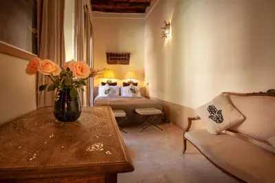 a room with a bed and a vase with flowers on a table at Riad KHOL Bohémia in Marrakech