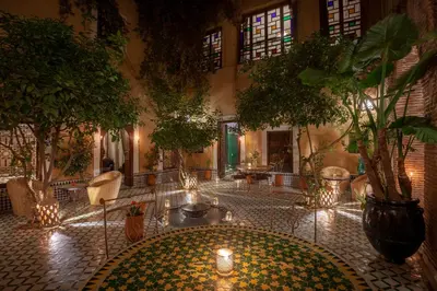 a room with a courtyard with trees and lights at Riad KHOL Bohémia in Marrakech